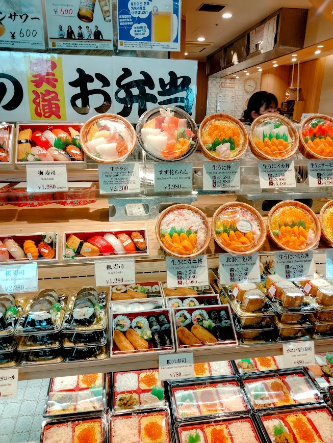 新千歳空港 保安検査後 搭乗待合室 「北の味覚すず花ゲート店」店先にならぶ種類豊富なお弁当 海鮮弁当、助六、握り寿司、海鮮丼など