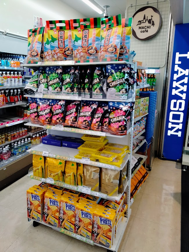 新千歳空港ローソンゲートラウンジ店内の棚に並ぶ、北海道土産のチェルシー北海道限定商品やプリッツの北海道限定商品など