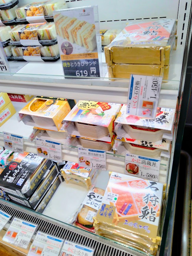 新千歳空港保安検査後エリア JALプラザ店内 佐藤水産海鮮系お弁当が並ぶ店内