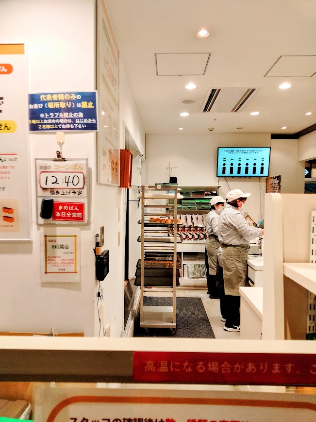 店舗内部。壁には次回のコーンぱん12:40焼き上げ予定と書かれた案内が貼られている