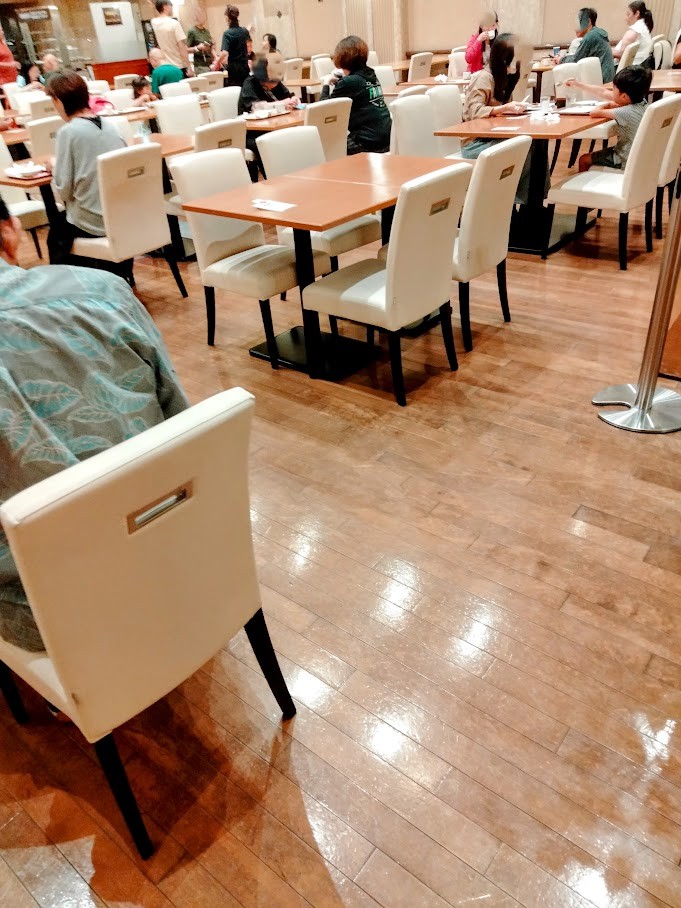 ホテルレストランの朝食会場内 椅子やテーブルに座る人。空いている席もある