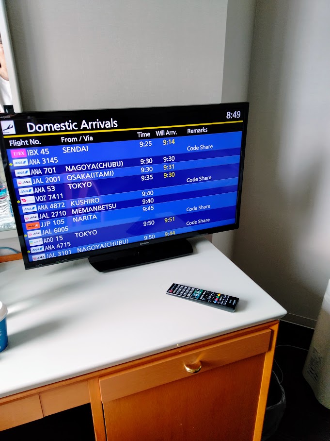 客室内デスクの上のテレビに映し出された離発着案内