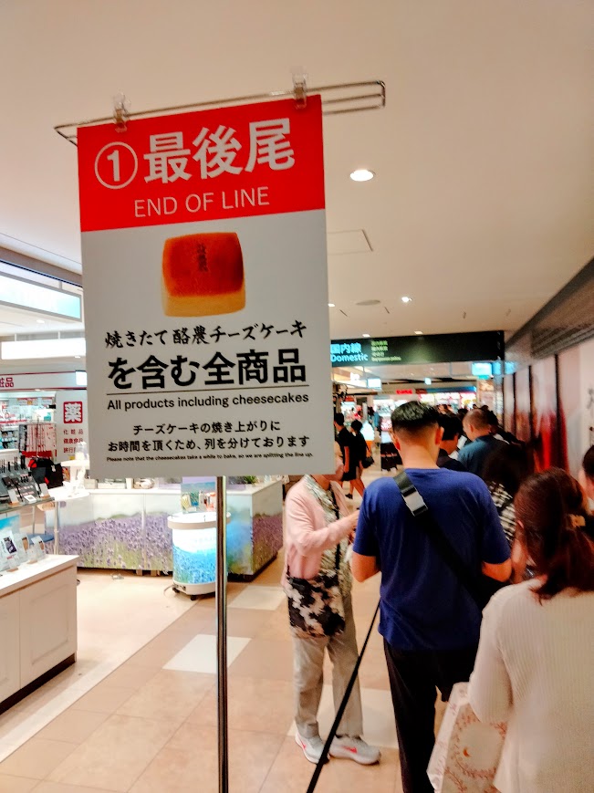 札幌農学校のチーズケーキを買うための列、最後尾と書かれた立て案内板