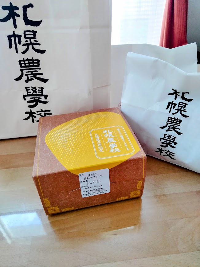 札幌農学校酪農チーズケーキを購入後、自宅テーブルの上に箱に入った酪農チーズケーキが置いてある