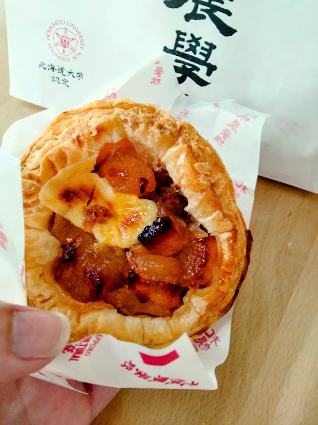 焼きたて北海道アップルパイを手に持っている