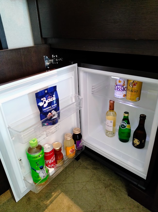 冷蔵庫の中にジュース、お茶、ビール、日本酒、ワインが入っている